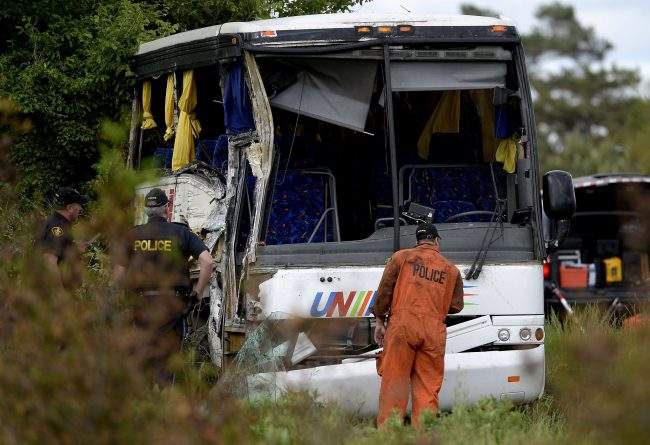OPP officers work at the site of a crash involving a tour bus on Highway 401 West, near Prescott, Ont., June 4, 2018. 