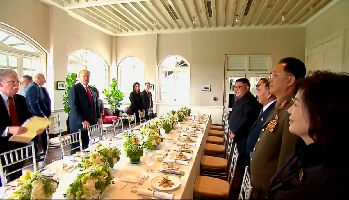 In this image made from video provided by Host Broadcaster Mediacorp Pte Ltd,, U.S. President Donald Trump, second from left, and North Korean leader Kim Jong Un, fourth from right, arrive for a working lunch at Capella Hotel in Singapore, Tuesday, June 12, 2018.