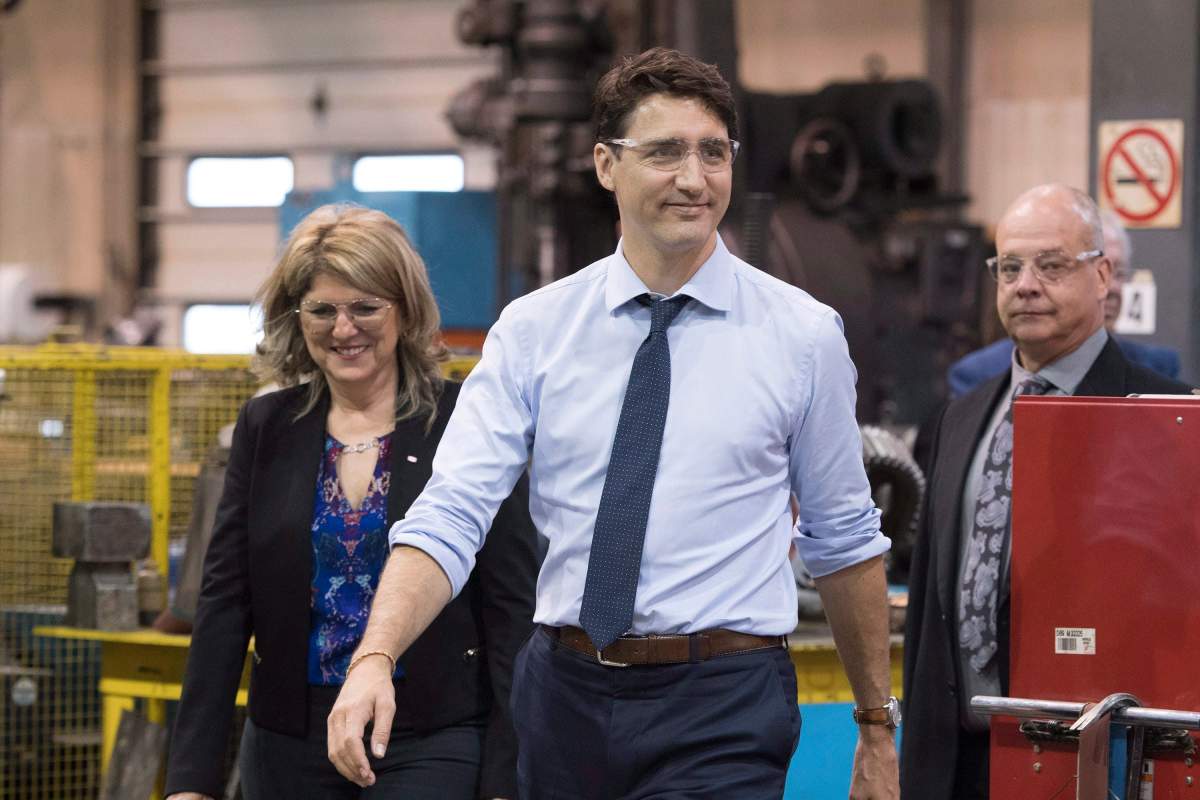 Prime Minister Justin Trudeau and local candidate Lina Boivin, left, visit a machine shop, Thursday, June 14, 2018 in Saguenay Que.