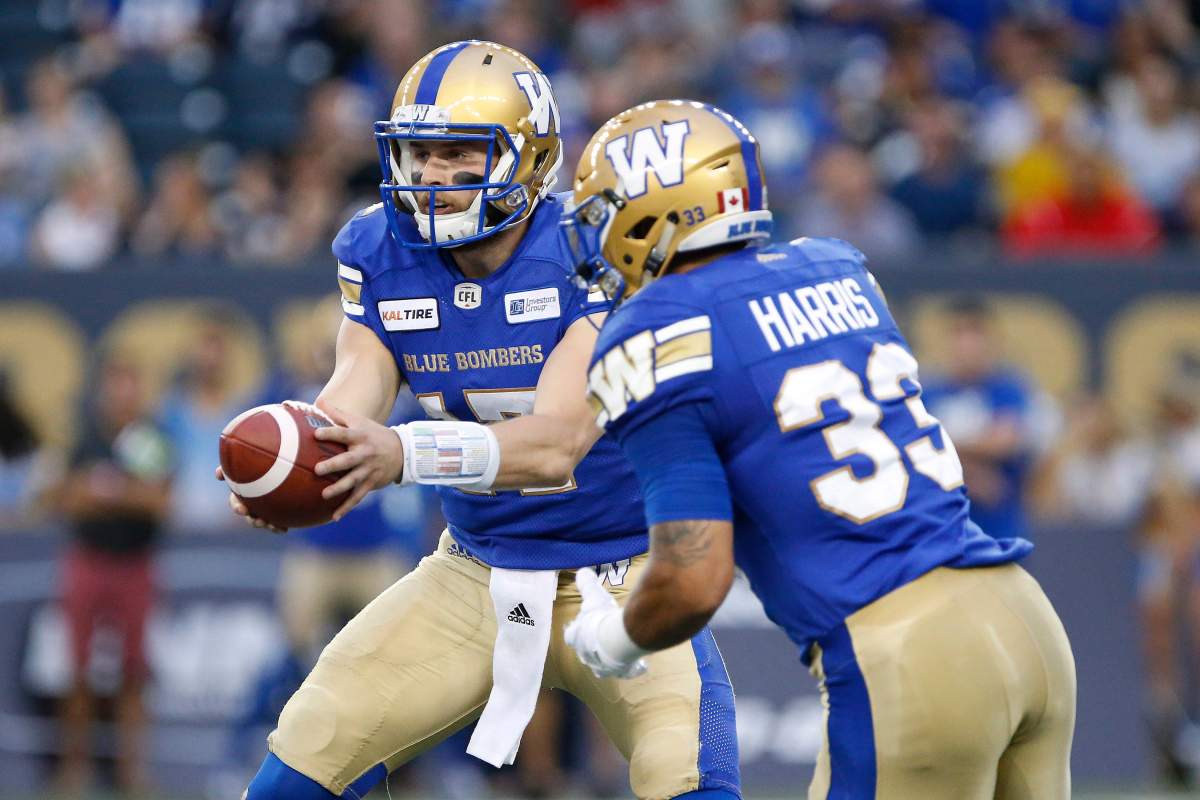 Winnipeg Blue Bombers quarterback Chris Streveler (17) hands off to Andrew Harris (33) against the Edmonton Eskimos during the first half of CFL action in Winnipeg Thursday, June 14, 2018. THE CANADIAN PRESS/John Woods.