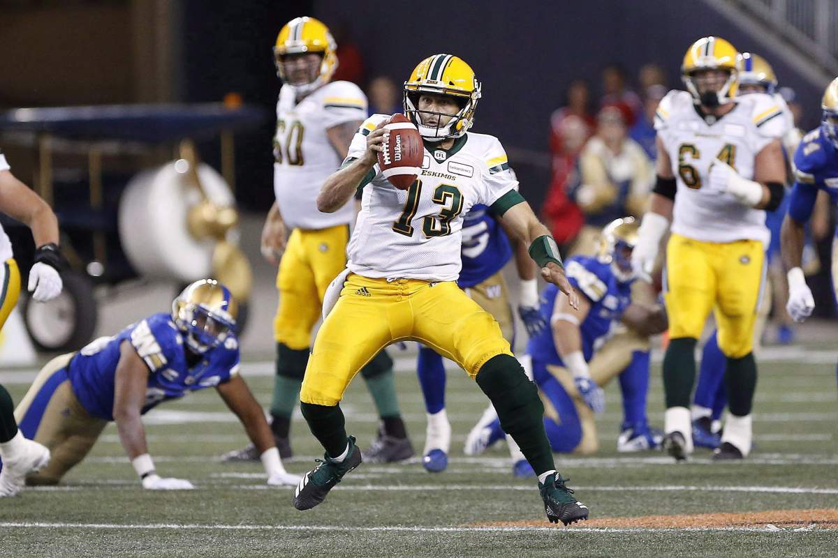 Edmonton Eskimos' quarterback Mike Reilly (13) scrambles for extra yards against the Winnipeg Blue Bombers during the first half of CFL action in Winnipeg Thursday, June 14, 2018. 