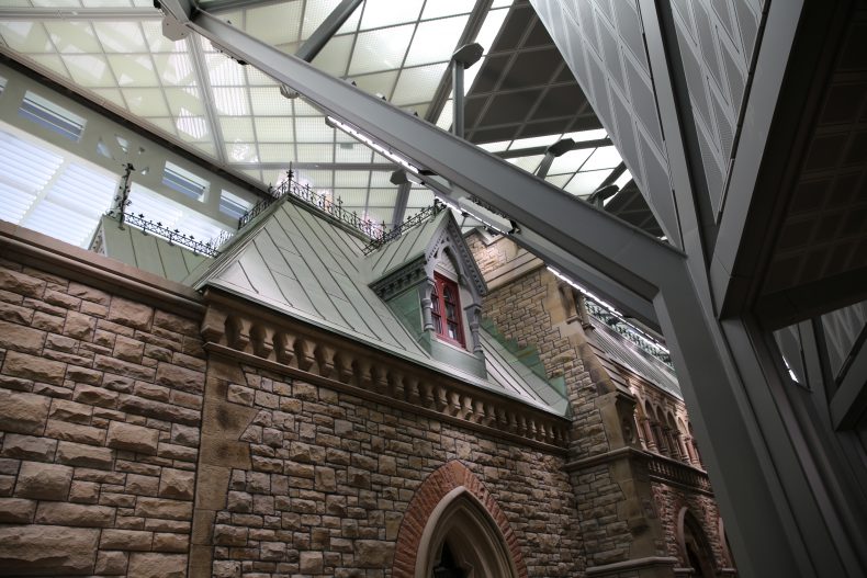 The new House of Commons showcases the iconic green copper roofs of the Parliament Building. The copper turns green over time as it is exposed to the elements. Since these roofs are covered by a ceiling, they would have never turned green naturally. Instead the construction team took used copper from the outside of the building and re-purposed it for the interior sections.