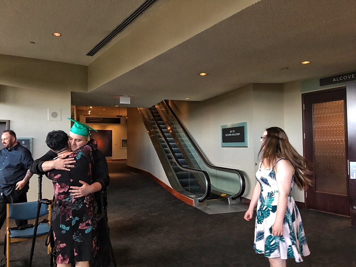 Alex McEwan in his exoskeleton in front of proud family and friends