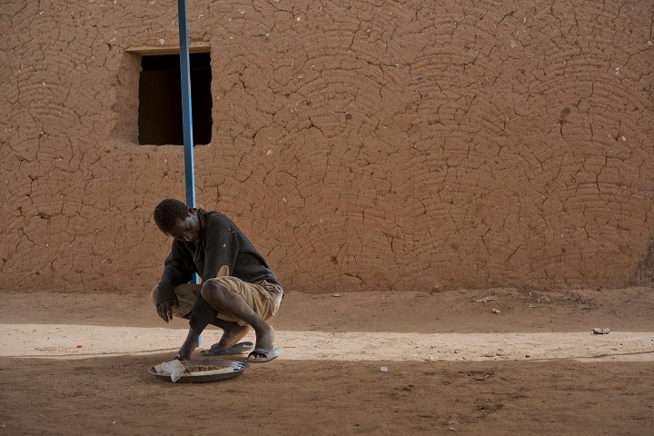 A young migrant who has been expelled from Algeria sits in a transit center in Arlit, Niger on Friday, June 1, 2018. Traumatized by his experience, he has not spoken and is helped by other migrants for food and bathing.
