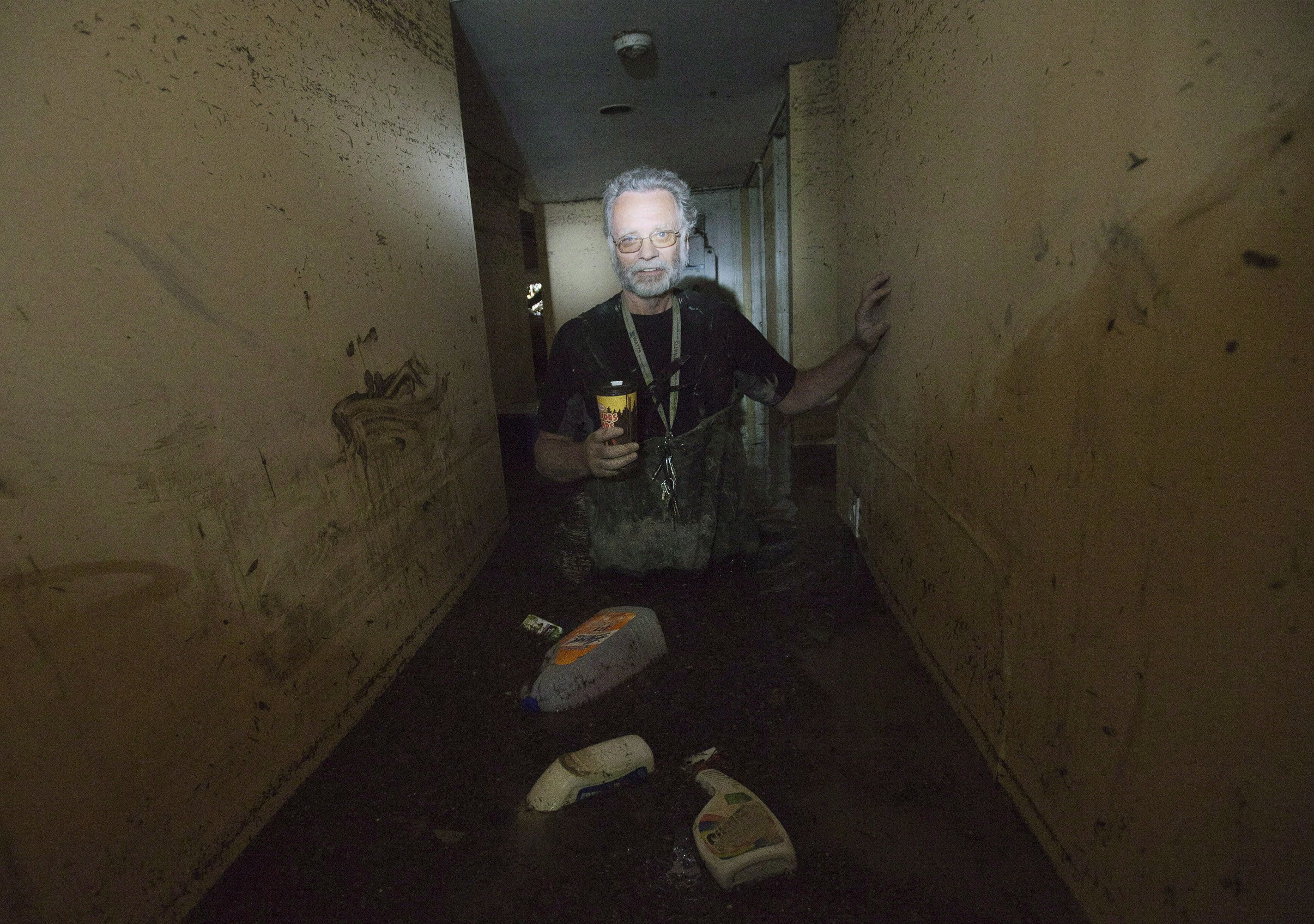Robert Watts walks in his flooded basement with hip waiters on as they try to pump the water out in the community of Bowness in Calgary, June 24, 2013. THE CANADIAN PRESS/Nathan Denette
