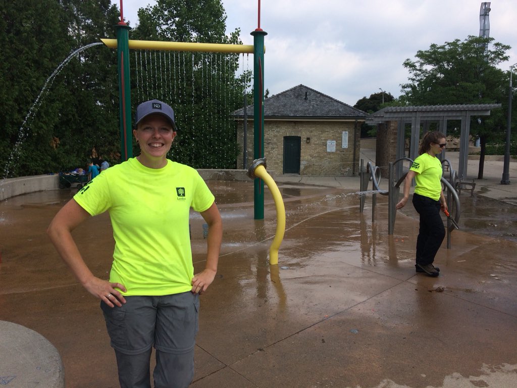 Caitlin Bye and her fellow grounds crew enjoy the splash pad at the Forks of the Thames, before getting to work planting annuals at Ivey Park. 