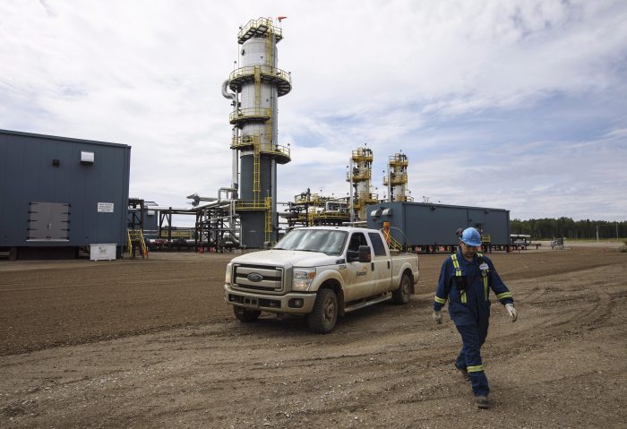 An employee walks around a group separator on a Suncor site in the oil sands in Fort McMurray Alta, on Monday June 12, 2017. 