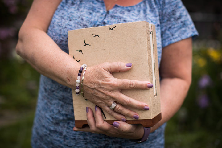 Wendy Gould holds the cremated remains of her late husband George Gould at her home, in Aldergrove, B.C., on Friday May 25, 2018.