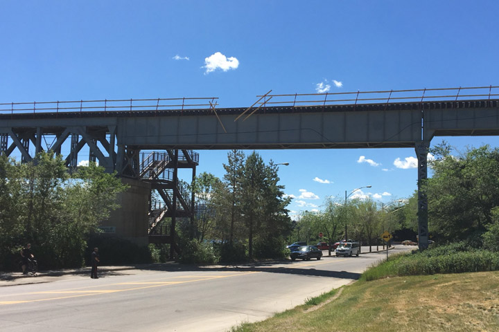 A Saskatoon police vehicle was damaged after a guard rail fell off the CP Train Bridge at Spadina Crescent.