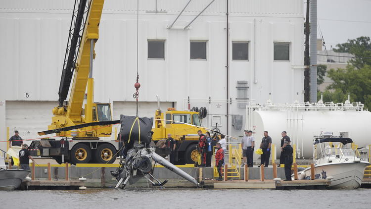 A helicopter is removed from the Fox River in Oshkosh, Wis., on June 9.