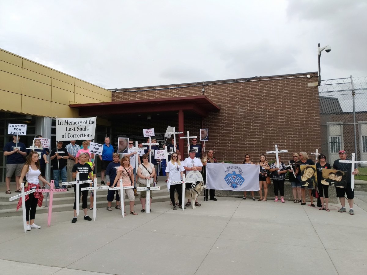 Those attending the rally stand outside the Elgin Middlesex Detention Centre. The crosses being held represent the 13 inmates who have died inside since 2009.