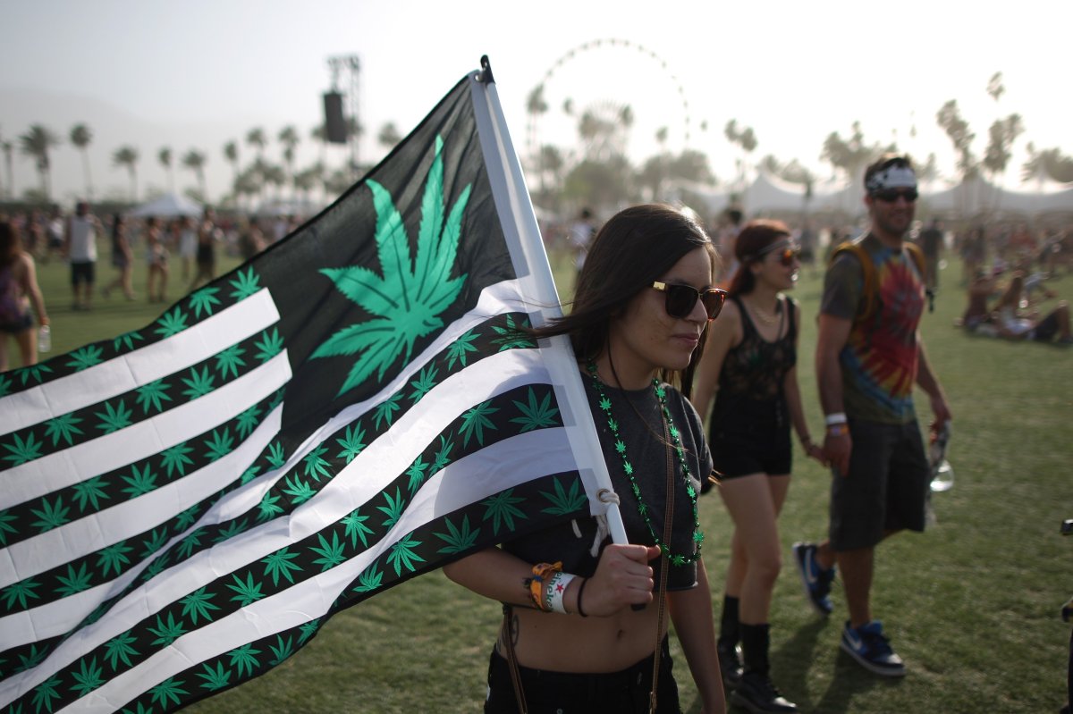 A woman carries a flag bearing marijuana symbols at the Coachella Valley Music & Arts Festival at the Empire Polo Club in Indio, California, April 12, 2014. 