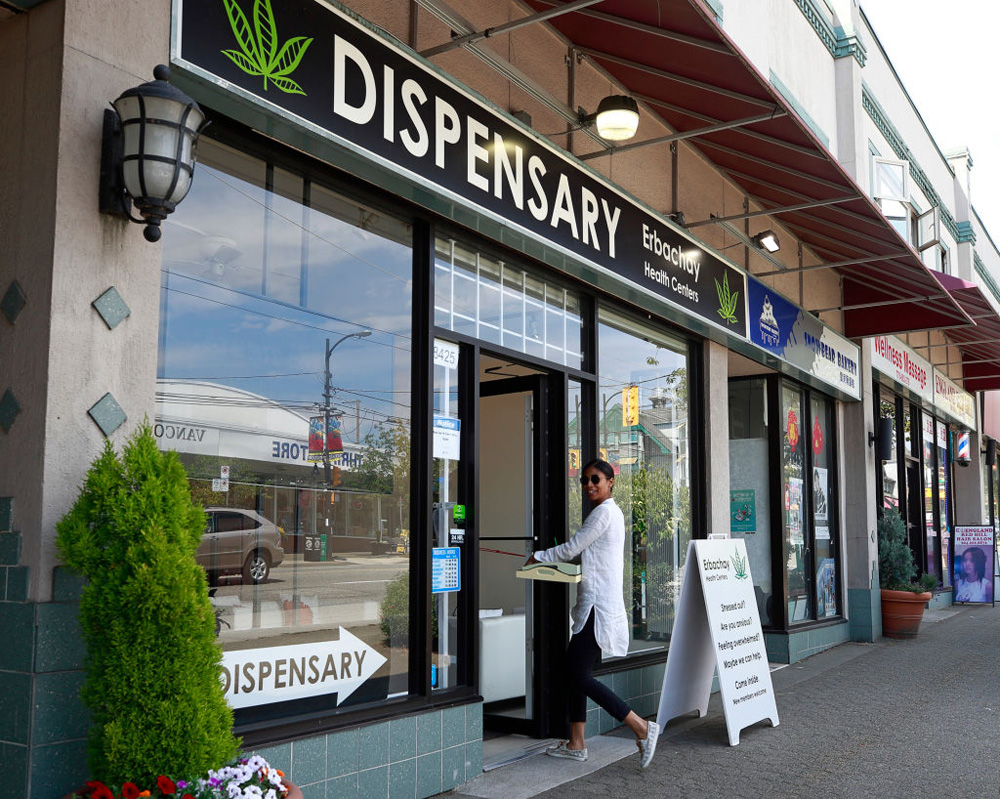 A woman walks into a marijuana dispensary on Granville Street on June 20, 2018, in Vancouver.