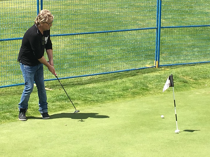 Johnnie Dee from Honeymoon Suite practices his short game at Sunset ranch golf course while waiting for soundcheck.