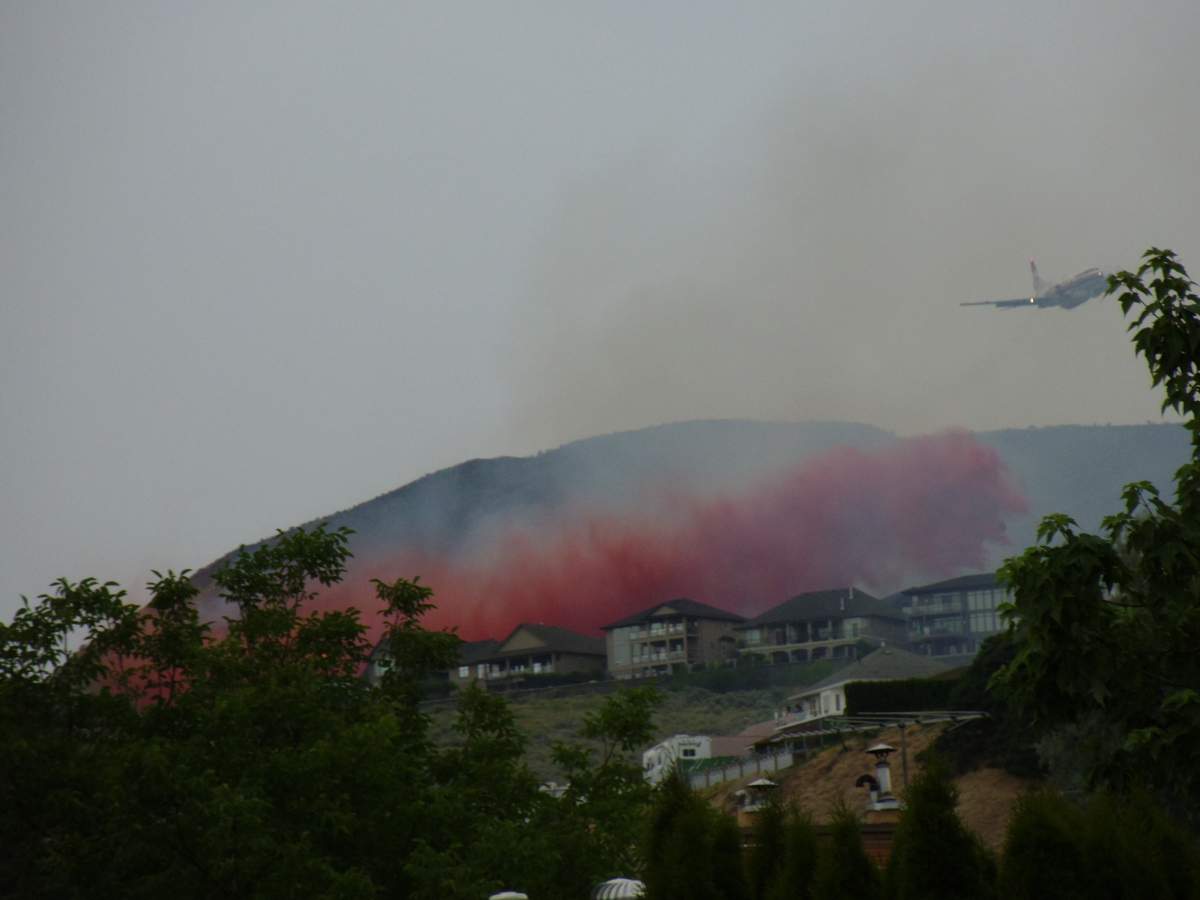 An aircraft helps to subdue a grass fire in Kamloops on June 21, 2018.