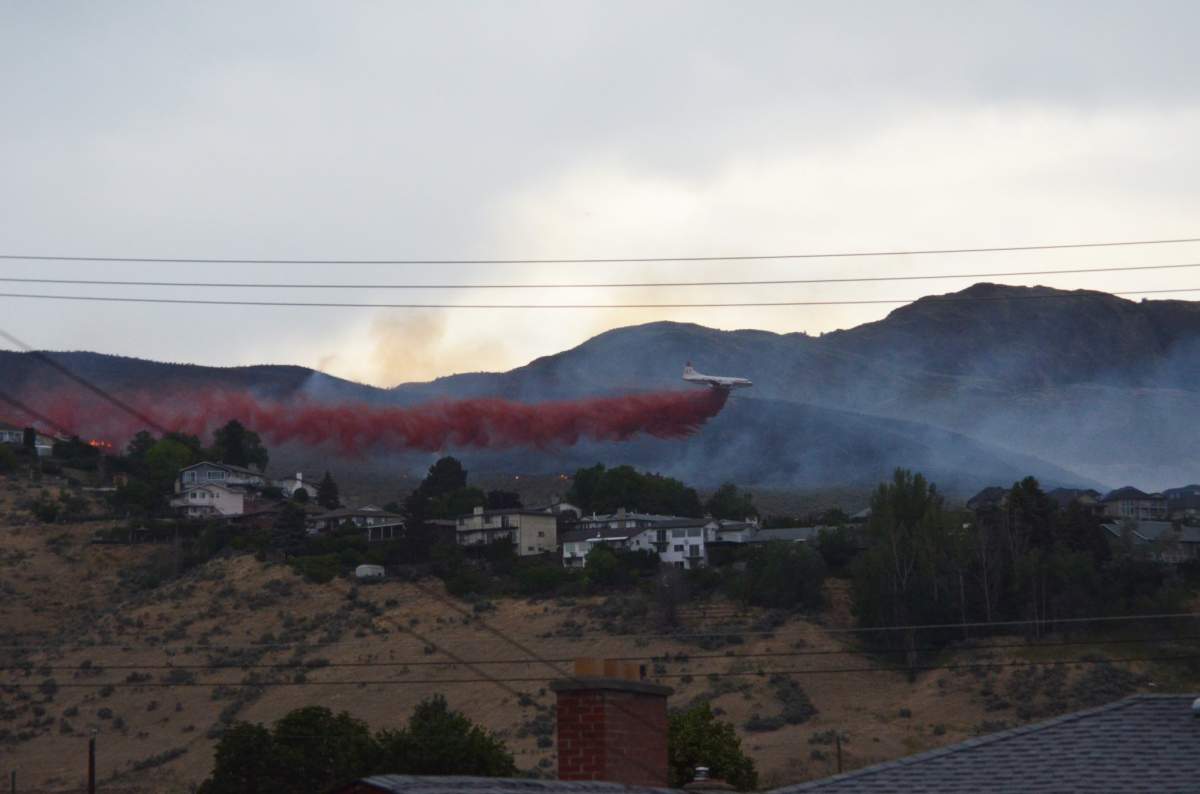 An aircraft drops a substance on a grass fire in Kamloops, June 21, 2018.