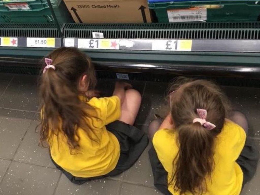 A mom-of-three in the UK has caused an uproar with a photo of her daughters sitting on the supermarket floor as punishment for being in "high spirits.".