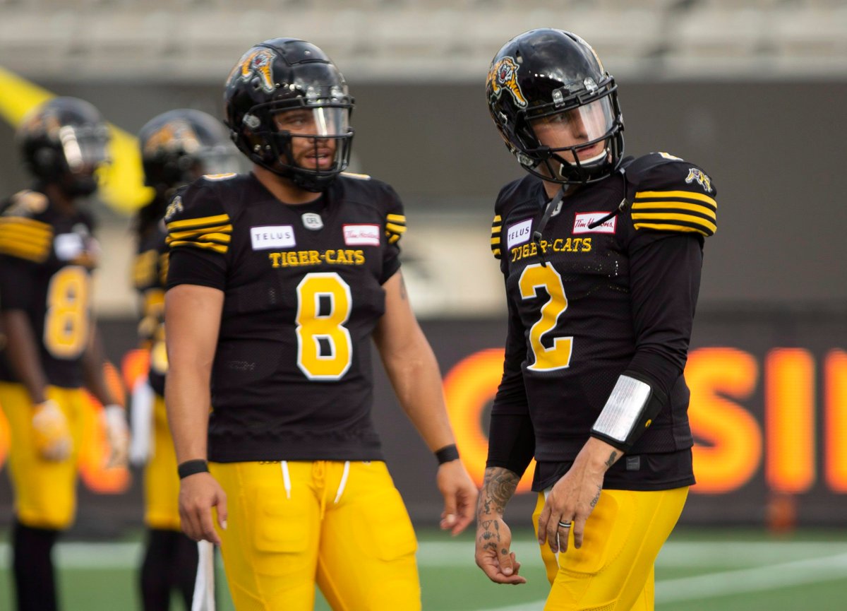 Hamilton Tiger-Cats quarterback Johnny Manziel (2), right and fellow quarterback Jeremiah Masoli (8) take part in the pre-game warm up before the CFL football exhibition game against the Toronto Argonauts in Hamilton, Ontario on Friday, June 1, 2018.
