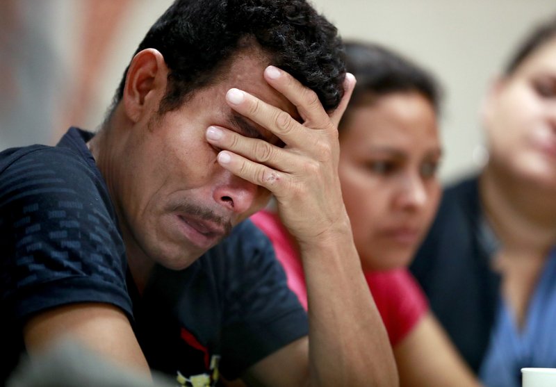 Melvin, foreground, and Iris, both from Honduras, listen as they hear other immigrants tell of their separation from their children.