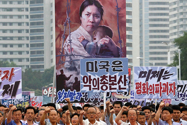 In this June 25, 2017 file photo, men and women pump their fists in the air and chant as they carry placards with anti-American propaganda slogans at Pyongyang's central Kim Il Sung Square, in North Korea.  