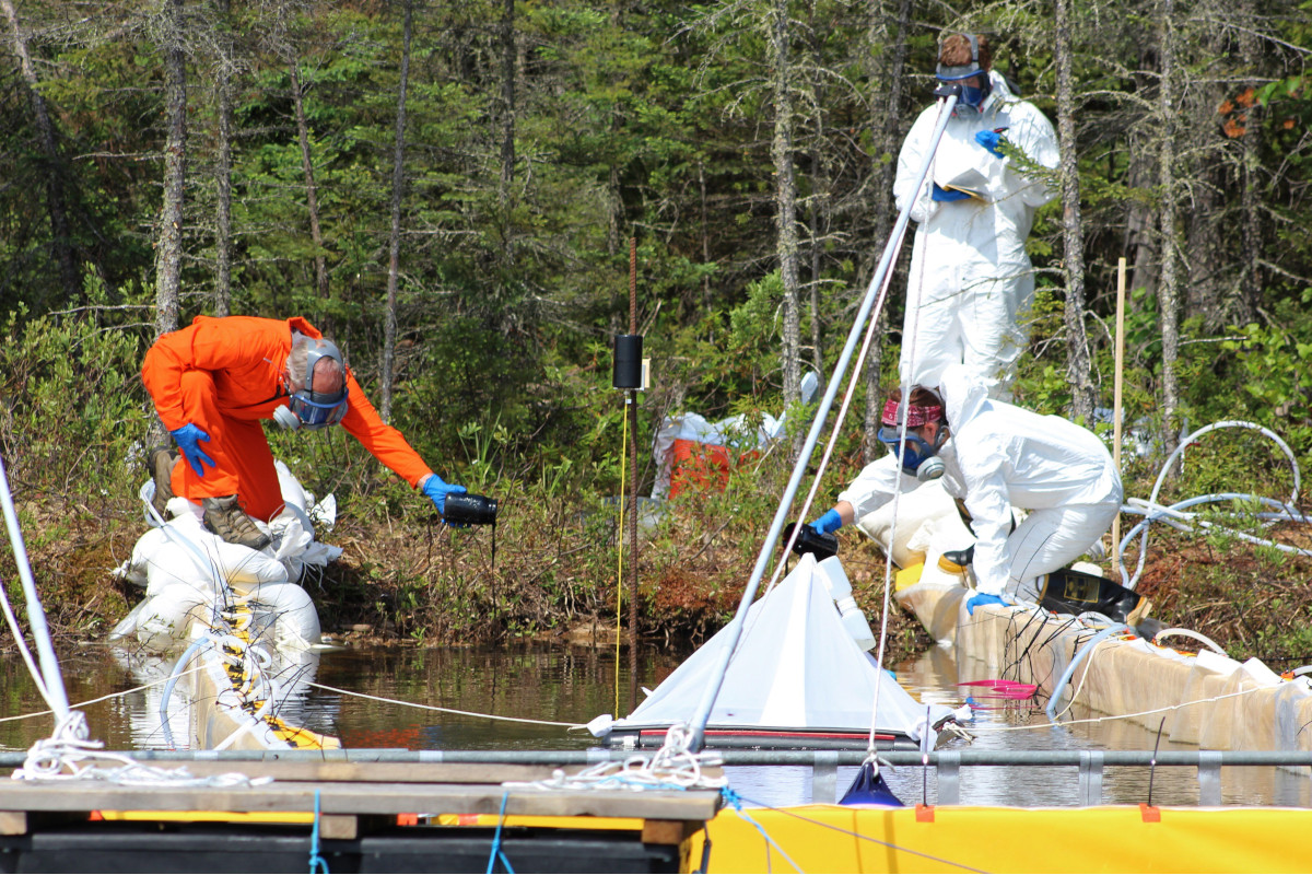 Researchers and professional spill responders monitor a deliberate spill of oilsands bitumen and crude oil into a lake in northwestern Ontario in an experiment over how the ecosystem responds in this undated handout photo. 