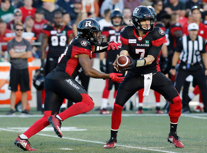 Ottawa Redblacks quarterback Trevor Harris (7) hands the ball to Ottawa Redblacks William Powell (29) during second quarter CFL action against the Saskatchewan Roughriders in Ottawa on Thursday, June 21, 2018. 