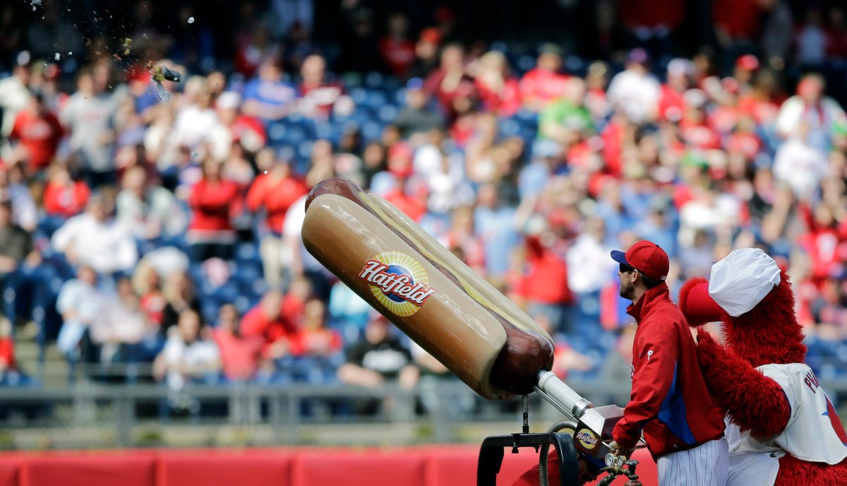 Philadelphia Phillies pitcher Cliff Lee, left, and team mascot, the Phillie Phanatic, launch a hotdog into the crowd during an exhibition baseball game against the Toronto Blue Jays, Saturday, March 30, 2013, in Philadelphia. Toronto won 10-4.