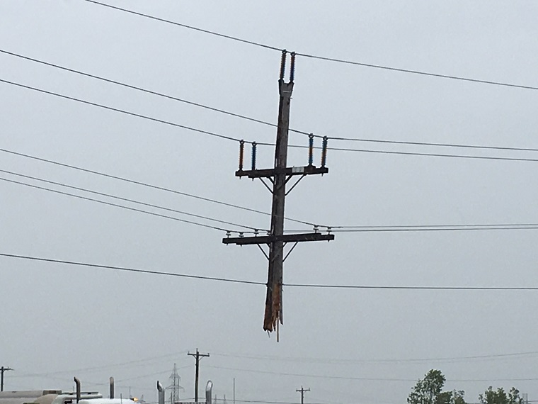 A hydro pole dangles from the wires after a semi crashed into it.