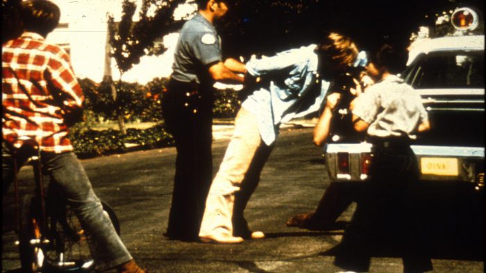 Police take a prisoner into custody for the Stanford Prison Experiment.