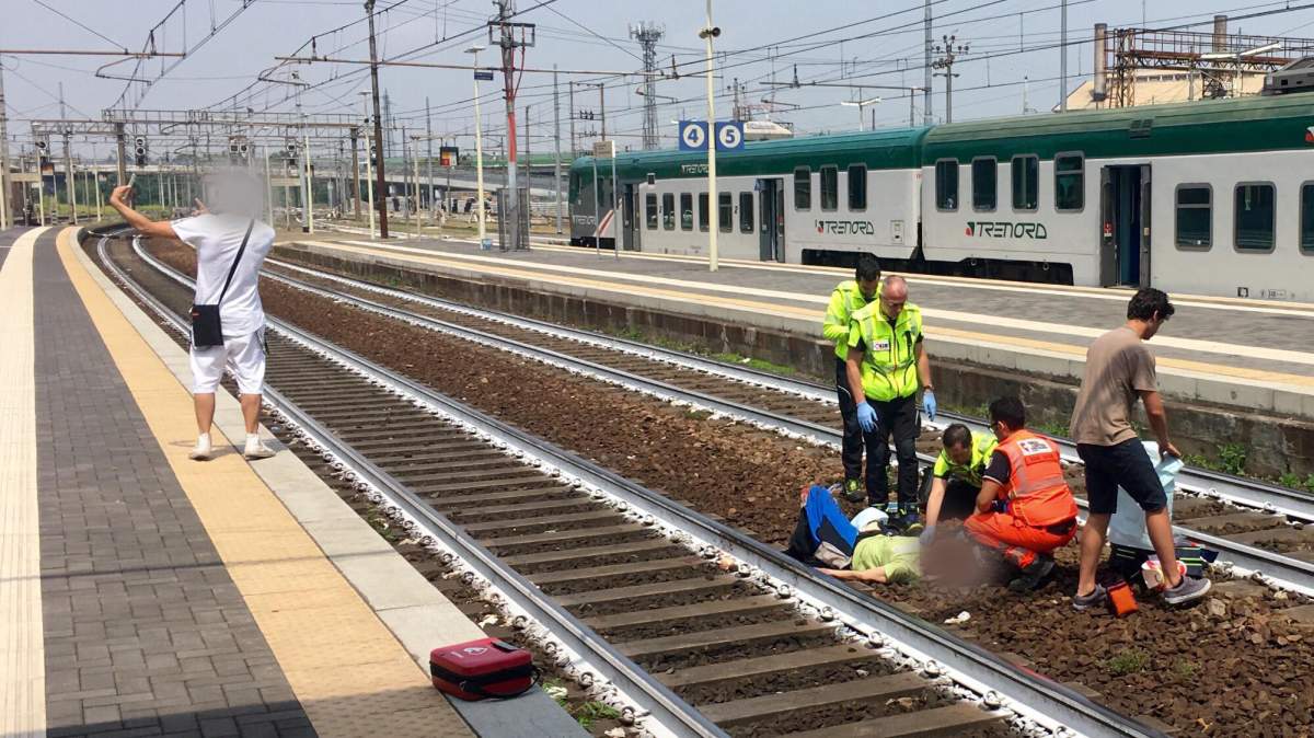 An unknown man takes a selfie as paramedics tend to a Canadian who was hit by a train in Italy. 