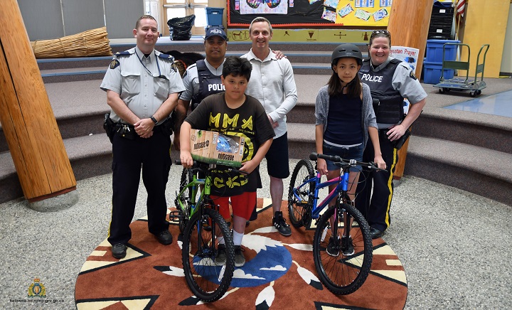 Cpl. Mike Williams, left, and Cst. Rolly Williams of the West Kelowna First Nations Policing Unit, Philip Johnston, principal of Sensisyusten House of Learning, and Cst. Sherri Lund of the West Kelowna RCMP stand behind Lee Mcdougall, 12, and Kaylynn Sandy, 11, who show their Nutcase helmets and new bicycles. The helmets were donated by BrainTrust Society while the bicycles were donated by the First Nations Policing Unit of the West Kelowna RCMP.