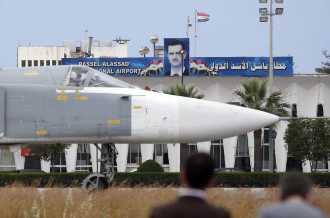 A Russian Su-24 bomber passes by a portrait of Syrian president Bashar al Assad at Hmeimym airbase in Latakia province, Syria, May 4, 2016.
