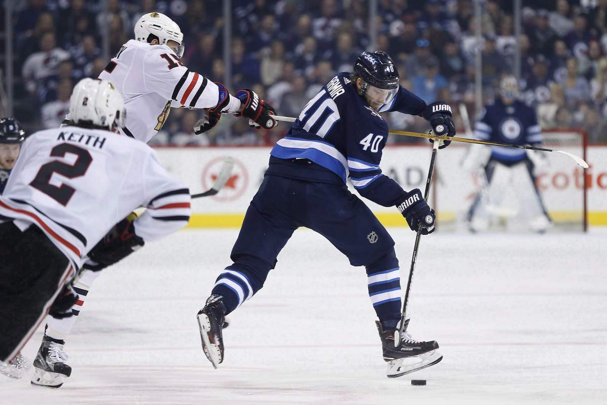 Winnipeg Jets right wing Joel Armia (40) is hooked by Chicago Blackhawks centre Artem Anisimov (15) as defenceman Duncan Keith (2) looks on during second period NHL hockey action in Winnipeg on Thursday, March 15, 2018. Armia will now be part of the Habs.