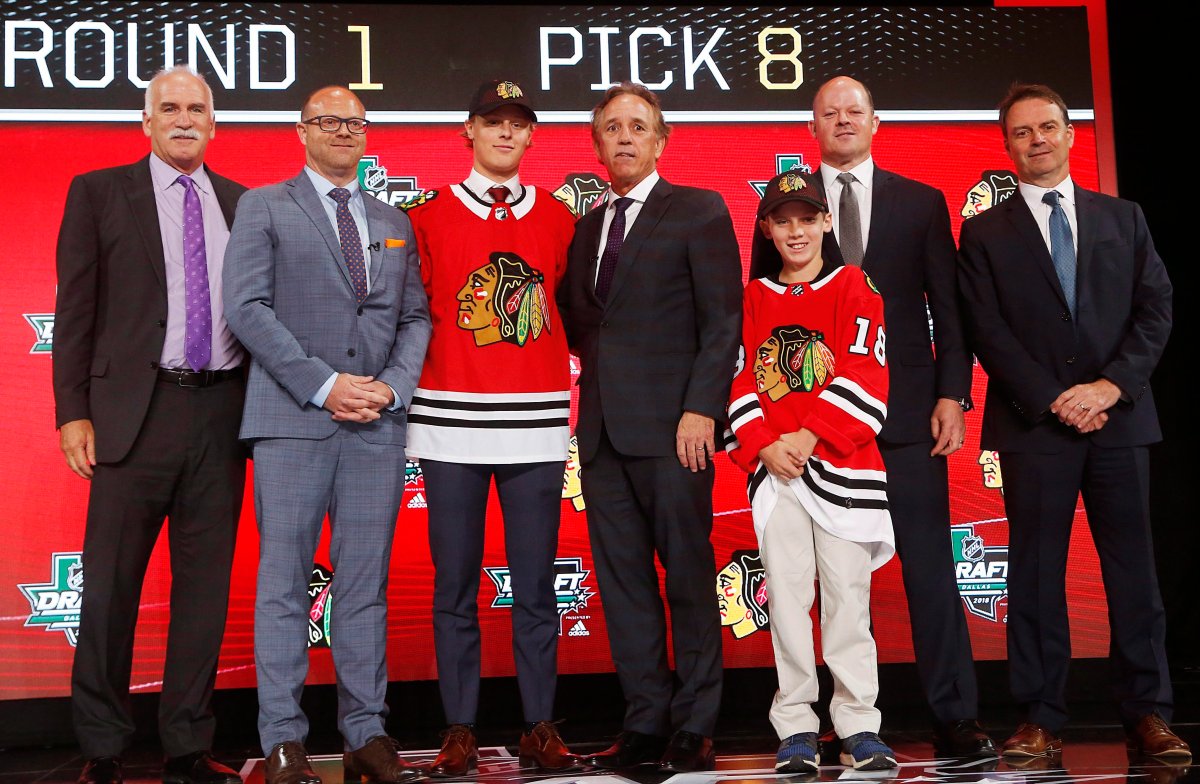 Adam Boqvist, third from left, of Sweden, poses after being selected by the Chicago Blackhawks during the NHL hockey draft in Dallas, Friday, June 22, 2018. (AP Photo/Michael Ainsworth).
