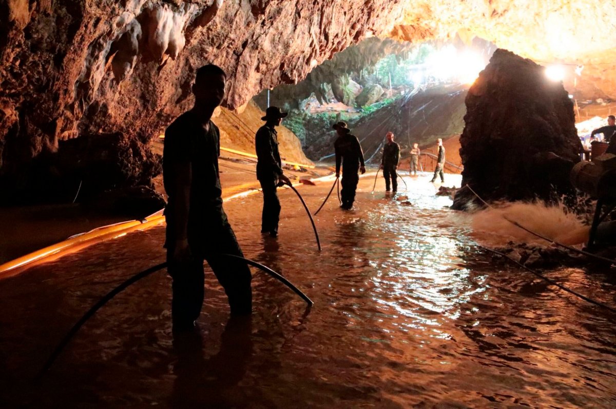 In this undated file photo provided by Royal Thai Navy on July 7, 2018, Thai rescue teams arrange a water pumping system at the entrance to a flooded cave complex where 12 boys and their soccer coach were trapped.