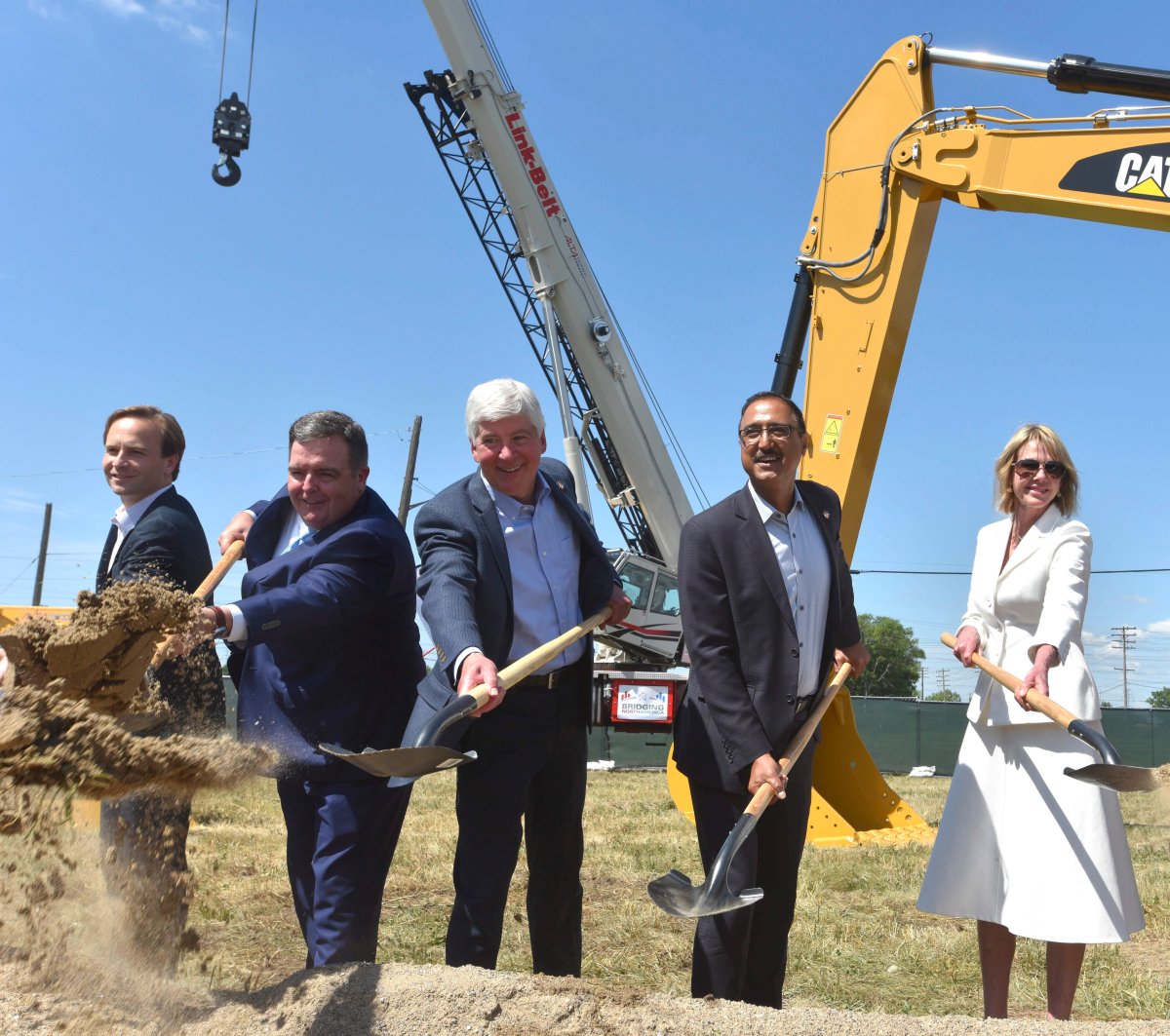 From left, Michigan Lt. Gov. Brian Calley, Dwight Duncan, chair of the Windsor-Detroit Bridge Authority, Michigan Gov. Rick Snyder, the Amarjeet Sohi, Canadian Minister of Infrastructure and Communities and Kelly Craft, U.S. Ambassador to Canada, shovel dirt during a ceremonial groundbreaking event for the Gordie Howe International Bridge in Detroit, Tuesday, July 17, 2018. 