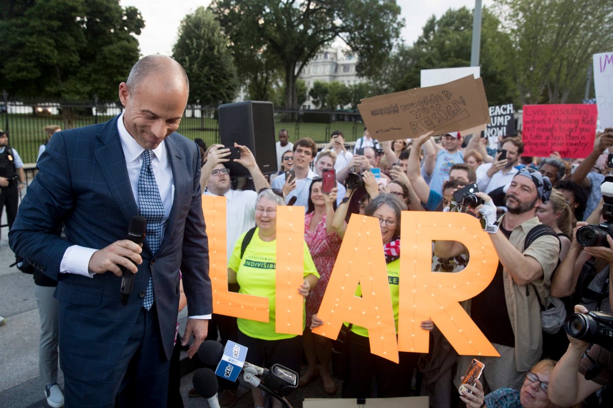 Members of the crowd hold letters that read "liar" as Michael Avenatti, left, attorney for porn actress Stormy Daniels, pauses while speaking at an Occupy Lafayette Park protest outside the White House, Tuesday, July 17, 2018, in Washington, D.C.