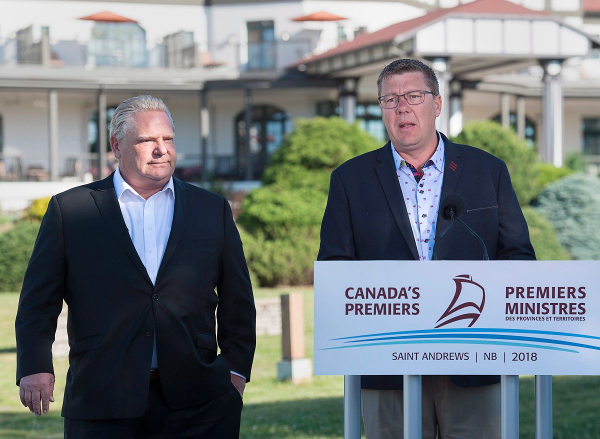 Ontario Premier Rob Ford, left, and Saskatchewan Premier Scott Moe, right, speak to reporters as the Canadian premiers meet in St. Andrews, N.B. on July 19, 2018.