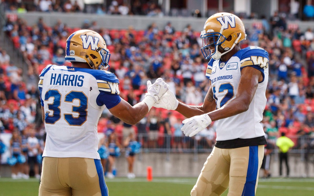 Winnipeg Blue Bombers' Andrew Harris celebrates his touchdown with teammate Adarius Bowman during first half CFL football action against the Toronto Argonauts, in Toronto on Saturday, July 21, 2018. THE CANADIAN PRESS/Mark Blinch.