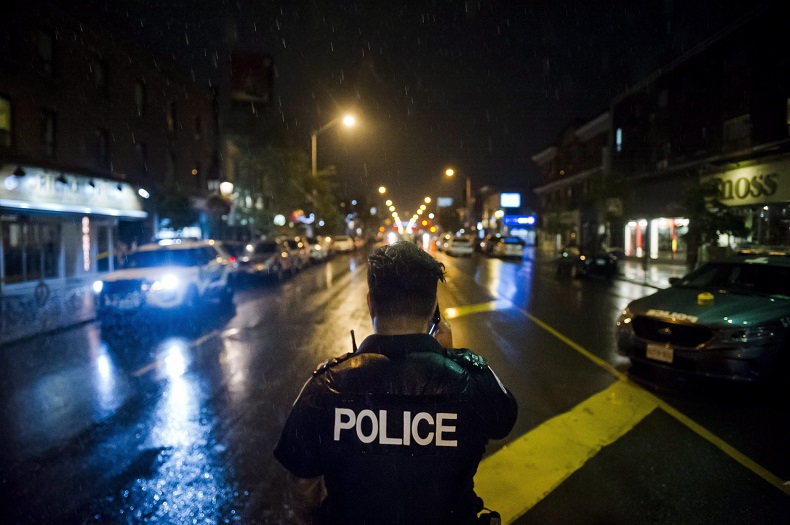 Police are seen around the scene of a shooting in east Toronto, on Monday, July 23, 2018. 