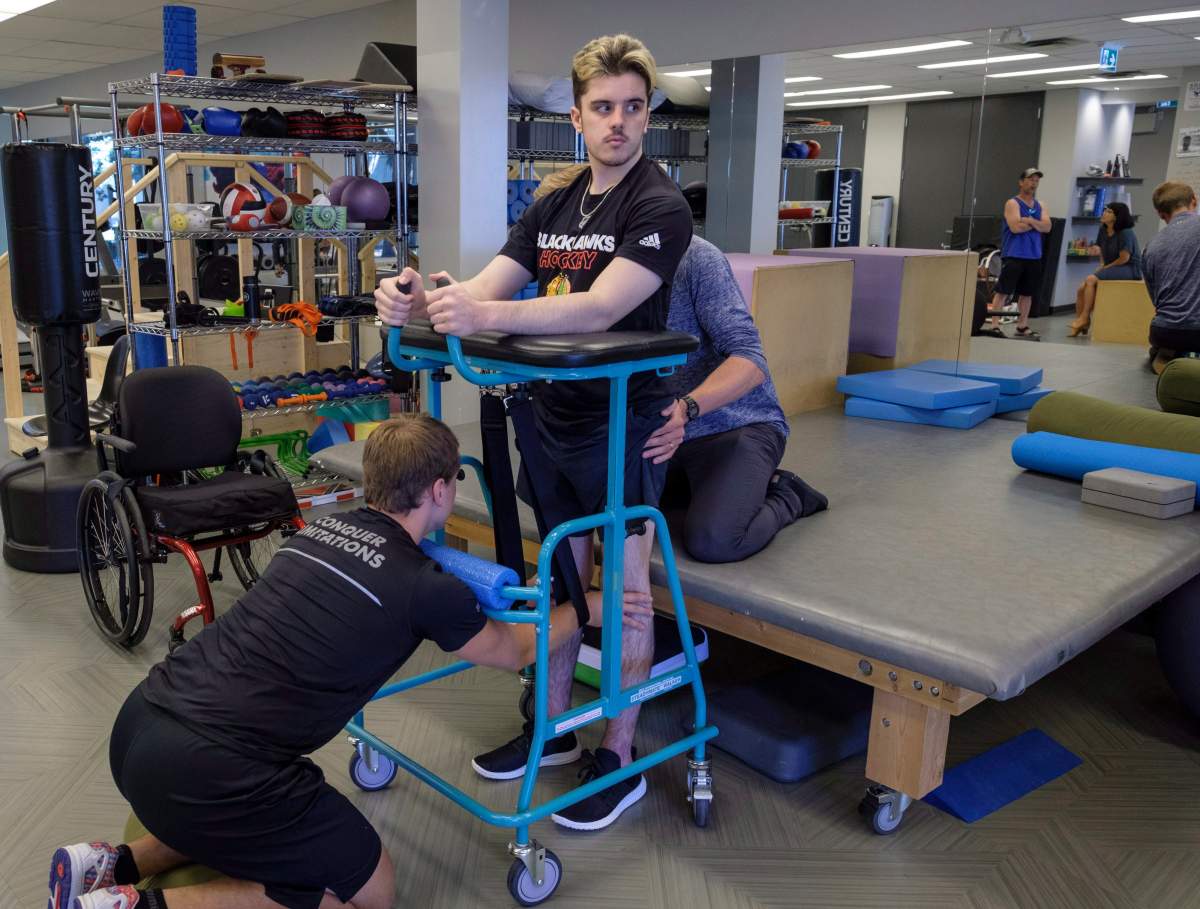 Humboldt Broncos bus crash survivor Ryan Straschnitzki, attends physio session with Kinesiologist Kirill Dubrovskiy, left, and physiotherapist Nelson Morela, right, in Calgary, Alta., Monday, July 16, 2018.