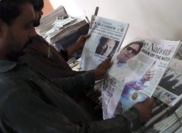 A person reads a Pakistani newspaper with a picture of Imran Khan, head of Pakistan Tehrik-e-Insaf (PTI) political party, on the front page a day after general elections in Karachi, Pakistan, July 26, 2018.
