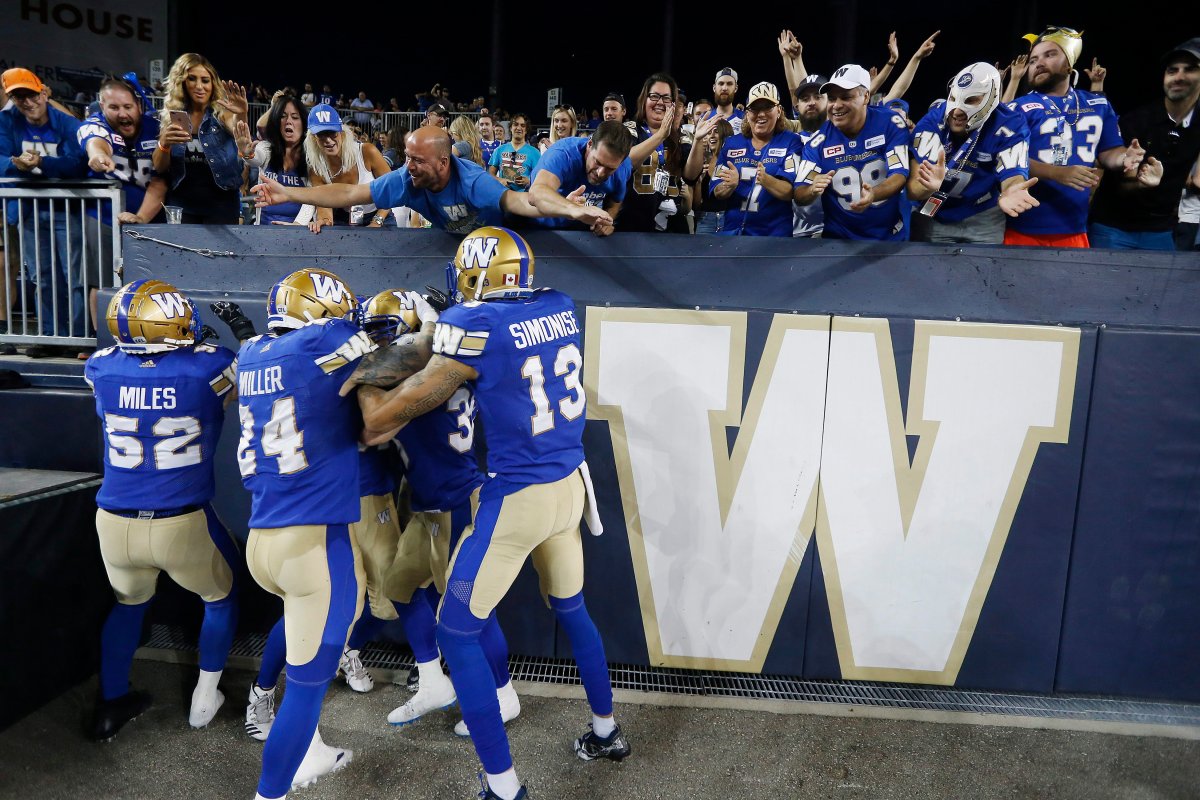 Winnipeg Blue Bombers' Ian Wild (38) celebrates with Thomas Miles (52), Mike Miller (24), Rashaun Simonise (13) and fans after running in a blocked kick for the touchdown during the second half of CFL action against the Toronto Argonauts in Winnipeg Friday, July 27, 2018. THE CANADIAN PRESS/John Woods.