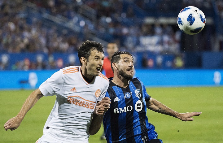 Atlanta United's Michael Parkhurst, left, challenges Montreal Impact's Ignacio Piatti during second half MLS soccer action in Montreal, Saturday, July 28, 2018. 
