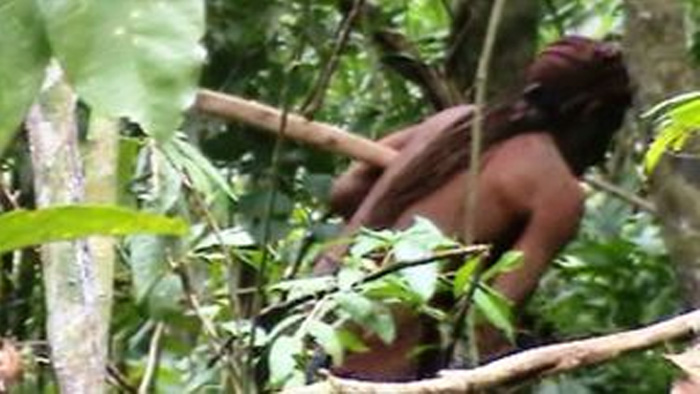 Brazil’s ‘Man of the Hole’ is shown fleeing into the forest.