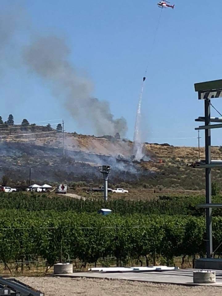 A helicopter dumps water onto the fire.