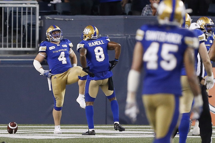 Winnipeg Blue Bombers' Adam Bighill (4) and Chris Randle (8) celebrate Bighill's interception and touchdown against the BC Lions' during the second half of CFL action in Winnipeg Saturday, July 7, 2018. 