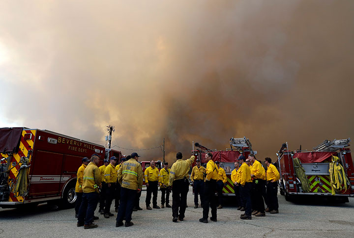 Firefighters from the Beverly Hills Fire Dept. stage along highway 74 Thursday, July 26, 2018, in Mountain Center, Calif.