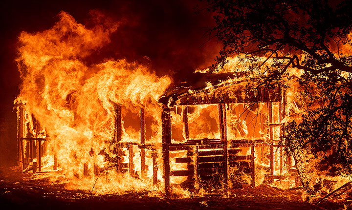 A structure burns as the Carr Fire races along Highway 299 near Redding, Calif., on Thursday, July 26, 2018.
