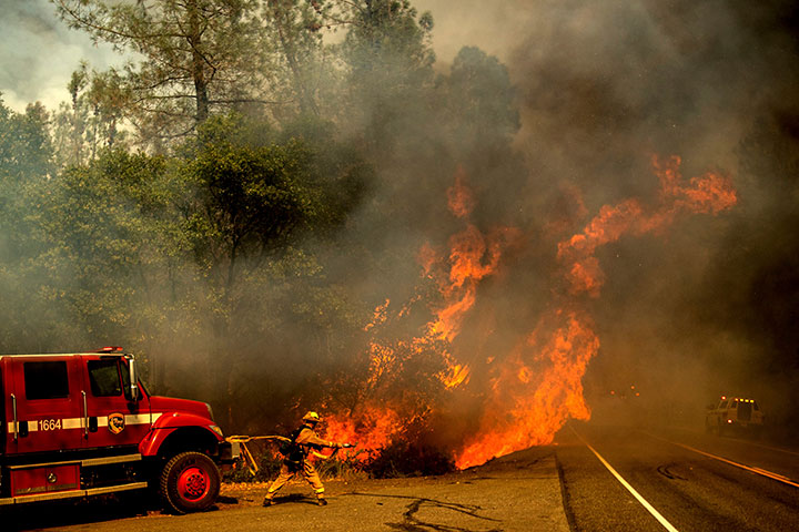 A firefighter battles the Carr Fire as it burns near Shasta, Calif., on Thursday, July 26, 2018.